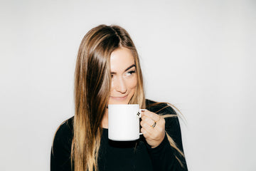 woman drinking tea from a white mug